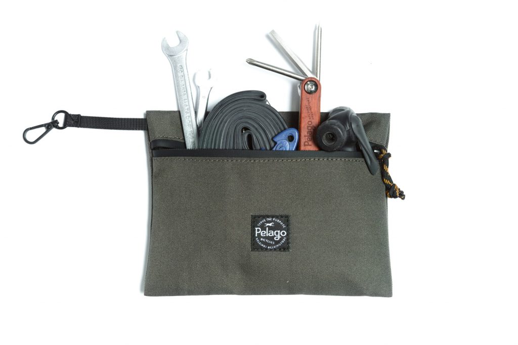 A green pouch with tools inside.