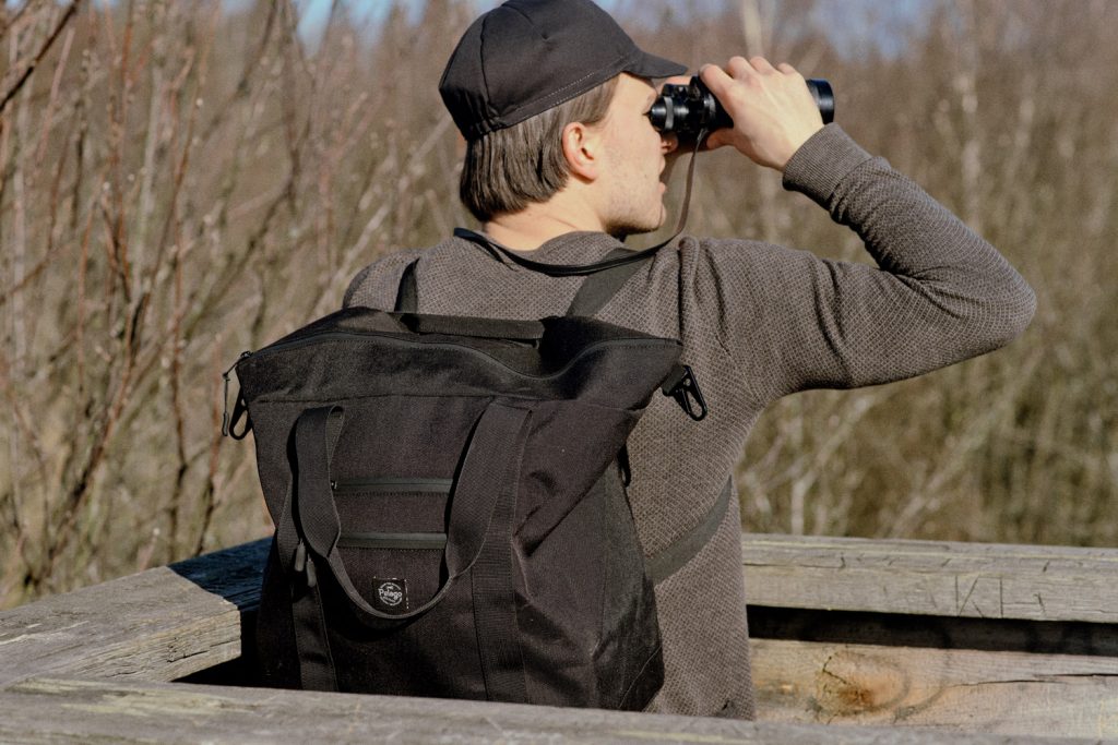 man with binoculars and a totepack