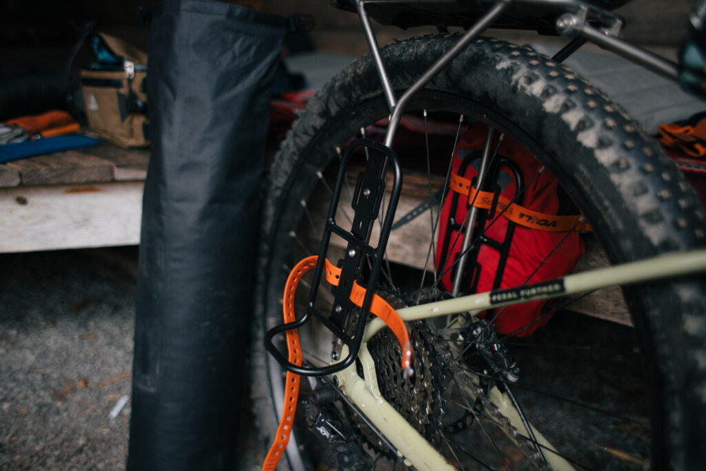 A fork rack with straps mounted to a bicycle rear rack.